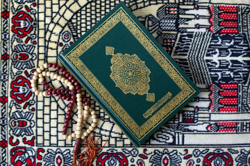 Quran - holy book of Muslims religion, Concept: open book holy prayers for god,
 Friday In the month of Ramadan  religion Islamic worshiping faith and learn koran and rosary put on wooden  boards 