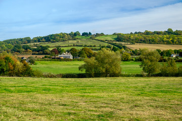 Fototapeta na wymiar The footpaths of Lacock offer lovely walks in green fields. The terrain is hilly but easy and quiet. The countryside of Wiltshire has a lot to offer.