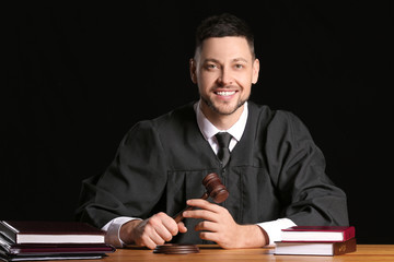 Male judge at table on dark background