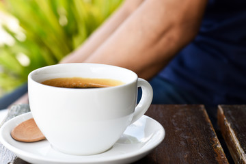 Close-up view, Black coffee in white cup on wooden table.