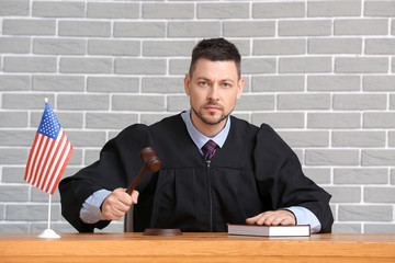 Strict male judge at table in courtroom