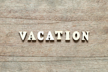Letter block in word vacation on wood background