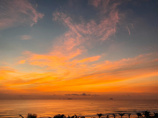 Fototapeta premium Dawn on the sea with a view of the horizon, colorful sky from sun rays, clouds on a blue sky