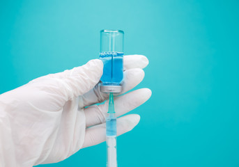 Glass medicine vial and a syringe on neo mint background. Vaccination
