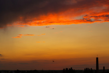 Black thunderclouds at sunset. Bright orange sunset and dark clouds. Storm sky