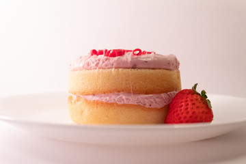 mini cake with strawberry on white plate