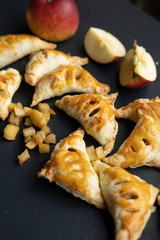 apple turnover on a dark concrete table with apple, horizontal view from above, flatlay, free space