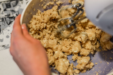 mixing ingredients with electric mixer to make cookies dough close up