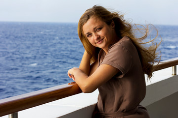 Young smiling girl on a  yacht  on the sea.The girl breathes fresh air in the open sea.