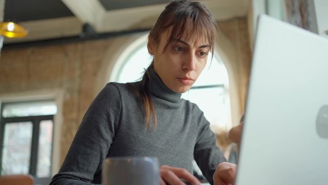 female student or freelancer working at laptop in cafe or coworking. remote work, self employment and study, solving task, research