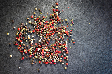 Red, green and black pepper on the black background. Peppercorn