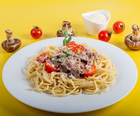 Spaghetti cooked pasta with ingredients on a yellow background. Colorful top and closeup view