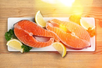 Fresh salmon steaks with parsley on white plate