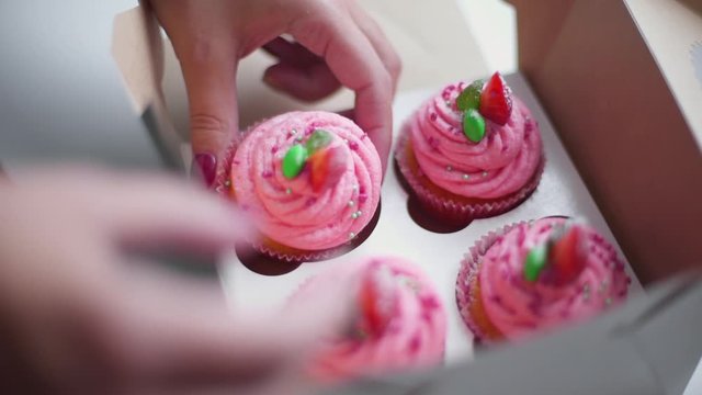 baker puts cupcakes into the box