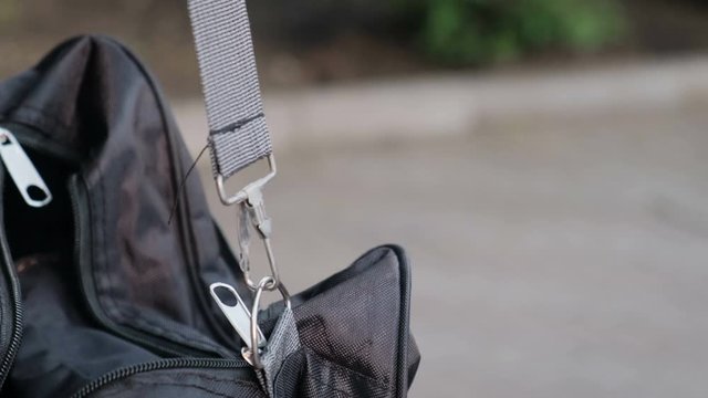 Hand of a thief stealing a sloppy lying purse in a bag, closeup