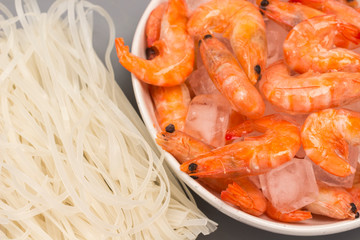 Rice noodles and prawns with ice in bowl.