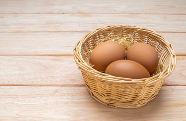 Eggs in the basket on pine wood table with coppy apace.