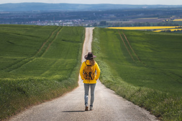 Long journey. Hiking woman walking on empty road. Travel concept. Getting away from it all