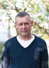 Portrait of handsome middle aged european man with mustache on backyard background in sunny spring day