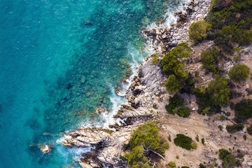 aerial top view of a clear ocean with rocky coast