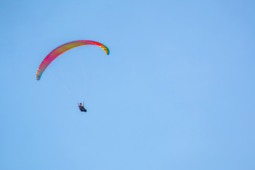 yellow paraglider on clear blue sky