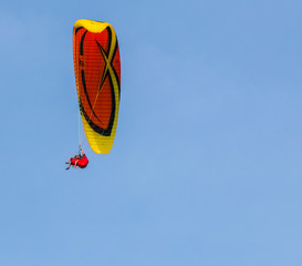 yellow paraglider on clear blue sky