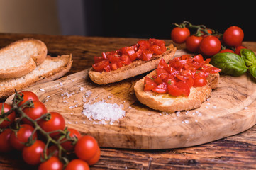 Italian bruschetta, toasted bred with fresh tomato and basil on woody vintage table
