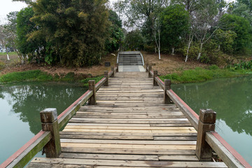 Fototapeta premium Wooden bridge over little river in city park