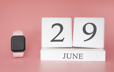 Modern Watch with cube calendar and date 29 june on pink background. Concept summer time vacation.