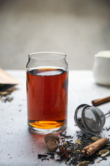 Black tea with spices, star anise, cinnamon, cardamom, nutmeg, clove on white table