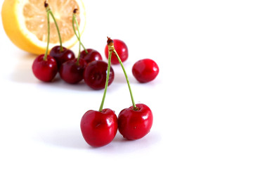 Cherries and lemon on a white background. Suitable for advertising backgrounds. Vitamin complex