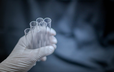 Scientist hand holding test tube and wearing surgical glove preparing to the science experiment in...