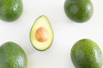 Whole fruits and half part of avocado. Top view. Isolated objects on white background. Fresh food or healthy diet concept