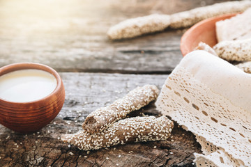 freshly baked fresh homemade breadsticks with sesame, homemade mayonnaise, hummus or white sauce on a wooden table. Country food. Rustic style