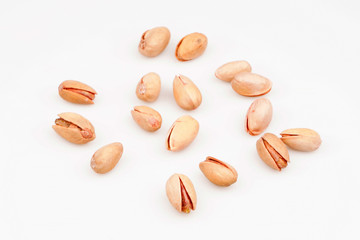 Organic pistachio nuts scattered on white background