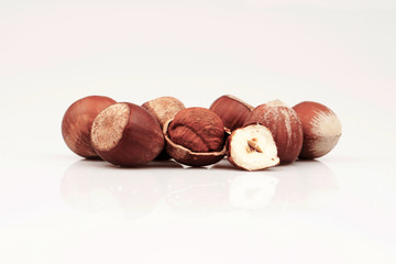 Organic and fresh shelled groats and half hazelnuts on white background