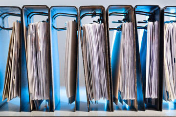 Office folders with archived paperwork in a row in blue light