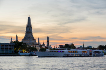 Fototapeta na wymiar Chao Phraya River Cruise Boat with Temple of the Dawn, Wat Arun, at Sunset in Background, Horizontal