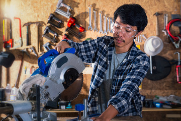 The carpenter is working on the wood cutting table in the wooden factory. Worker or Professional constructor repair workshop in wood working.