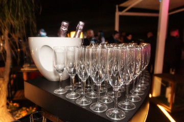 Sparkling wine bottle in the ice bucket and wine glasses in a restaurant setting