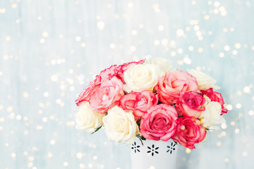 Beautiful pink and white roses in vase on blue background. Copy space, Holiday background. Mother's day, Valentines Day, Birthday celebration concept.