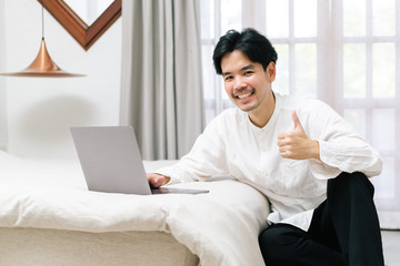 Fototapeta na wymiar Attractive asian male working with computer laptop at home. Work from home concept.