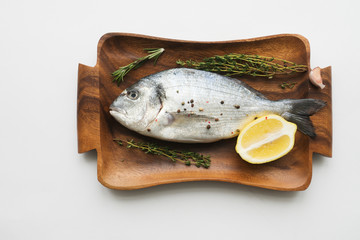 Raw fish cooking and ingredients. Dorado, lemon, herbs and spices. Top view on stone table