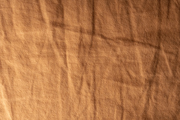 Crumpled brown fabric, fabric surface with shadows