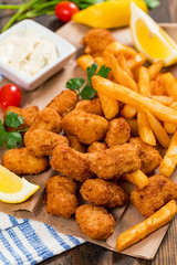 Crispy Fish Bites Snack Size. Deep Fried Pollock Fish Fingers and French Fried Potatoes with Tartar Dipping Sauce. Selective focus.