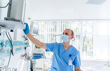 Doctor in mask. Special modern chamber in hospital. Modern medical bed and a special device in the...