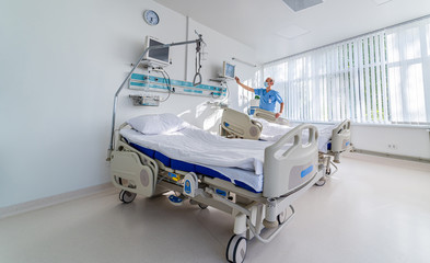 Doctor in blue medical clothes and mask is looking at the screen with health parameters on it....