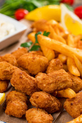 Crispy Fish Bites Snack Size. Deep Fried Pollock Fish Fingers and French Fried Potatoes with Tartar Dipping Sauce. Selective focus.