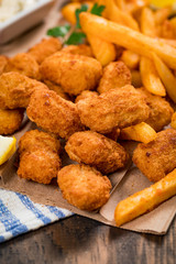 Crispy Fish Bites Snack Size. Deep Fried Pollock Fish Fingers and French Fried Potatoes with Tartar Dipping Sauce. Selective focus.