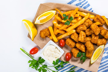 Crispy Fish Bites Snack Size. Deep Fried Pollock Fish Fingers and French Fried Potatoes with Tartar Dipping Sauce. Selective focus.